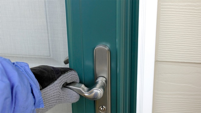 hand on the handle of a security screen door